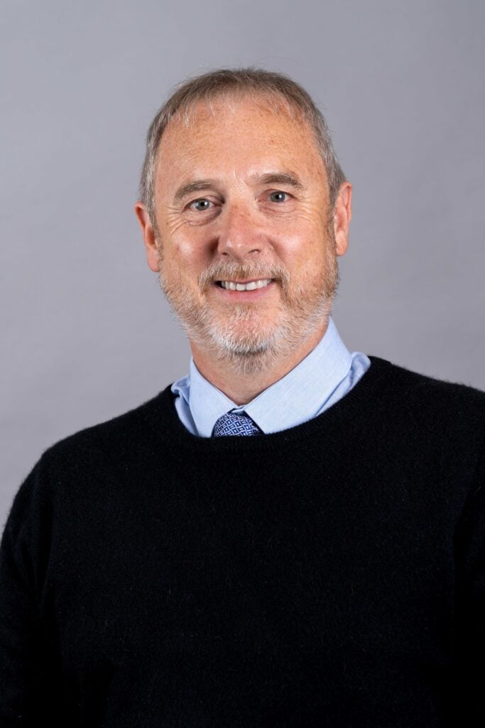 Image of Tony Deakin in a Blue Jumper over a shirt and tie